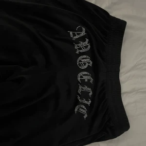 Svarta velour mjukisbyxor  - Svarta velour mjukisbyxor med text bak