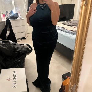 Mörkgrön balklänning/ festklänning  - Säljer min fina mörkgröna balklänning med öppen rygg & med en fin halterneck i sammet material pga flytt & att den har använts bara en gång och bara hängt i garderoben sen dess. Är 163 och den har lite släp efter sig om man ser på bilderna. Köptes för 2000 i göteborg men säljs för 1400, vid snabb affär kan priset diskuteras :) går att mötas upp om du bor i närheten av Karlstad! (Storleken är L men passar som M då den sitter lite åt)