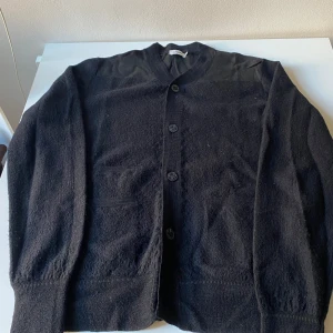 Svart kofta med knappar - Säljer en klassisk svart kofta i bra skick Den har långa ärmar och knappar framtill. Perfekt för både höst och vinter, och funkar lika bra till vardags som till lite finare tillfällen. Ett måste i garderoben!