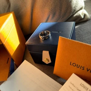 Ring Vitt guld från Louis Vuitton - Säljer en elegant rings guld  från Louis Vuitton. Ringen har en stilren design med märkets ikoniska logotyp ingraverad. Perfekt för både vardag och fest! Kommer med originalförpackning och certifikat. Passa på att köpa denna lyxiga accessoar!