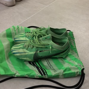 Nike mercual vapor 15 ag, MDS 008 - Säljer ett par grymma gröna fotbollsskor från Nike. De har en cool randig design med snörning och är i mycket bra skick. Perfekta för fotbollsträning eller match! Sulan har Zoom-teknologi för extra komfort och grepp. Köpta för 3300kr i mars, använda men finns en säsong eller två kvar;)