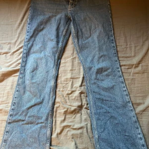 Blå jeans från Gina Tricot - Säljer ett par snygga blå jeans från Gina Tricot i storlek 38. De är i nyskick då ja inte har använt dom sen ja köpte dom! 👖✨ modellen heter full lenght flare. Midjemåttet är 74 och innerbensmåttet är 81