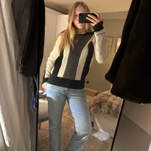 Stickad tröja med svart och beige mönster - Säljer min coola stickade tröja från Dagmar i svart och vit. Den har ett unikt randigt mönster och långa ärmar. Perfekt för höst och vinter, och den är supermysig att ha på sig. Den är knappt använd!💗