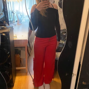 Röda byxor - Röda byxor med uppknäppbara knappar! Materialet är i någon form av silke, super snygga!!