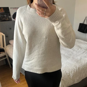 Vit stickad tröja från Vero Moda - Säljer en supermysig vit stickad tröja från Vero Moda. Den har långa ärmar och en klassisk rund halsringning. Perfekt för kyliga dagar och kan enkelt matchas med både jeans och kjol. Tröjan är i bra skick men har en liten defekt som syns på bilden. Passa på att fynda denna stilrena tröja!