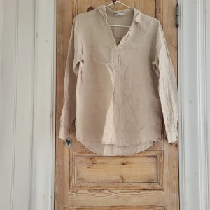 Beige linneblus/skjorta - Endast använd 1 gång, mycket bra skick. Den är i storlek 34, men passar också 36/38.
