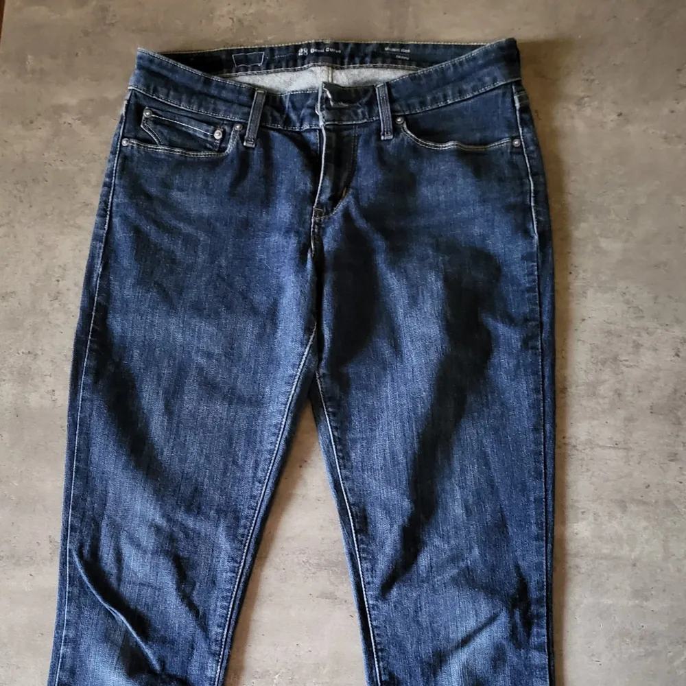 Säljer ett par snygga Levis jeans i mörkblå denim. De är i modellen Demi Curve med modern rise och skinny passform. Jeansen har klassiska fem fickor och en dragkedja med knapp framtill. Perfekta för både vardag och fest!. Jeans & Byxor.