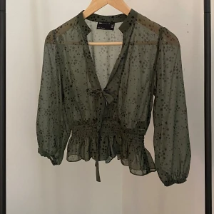 Grön blus - Supersöt grön blus med svarta stjärnor på. Ganska genomskinlig och kort på längden, pga detta skulle jg säga att den mer passar som en xs än en s. Jättesöt knyte där fram och i mycket bra skick, perfekt till hösten!!