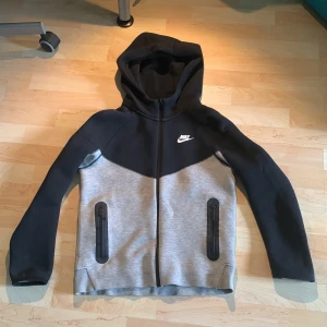 Grå/svart Nike techfleece - Säljer min Nike tech fleece för att den var för liten för mig använt fåtal gånger skick 9/10 har inte sett ngt fel med den. Ska passa 147-158 kan pruta