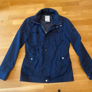 J.Lindeberg jacka - Säljer nu en J.Lindeberg jacka perfekt inför hösten! Knappen längst ner har ramlat av men går lätt att sy på igen. Skick 8/10. Hör av er vid frågor!