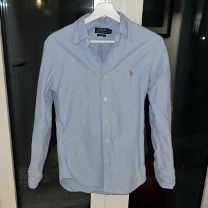 Ljusblå skjorta från Ralph Lauren - Säljer en stilren ljusblå skjorta från Ralph Lauren i slim fit storlek S. Den är inte använd många gånger därför då är i bra skick. 1600kr!