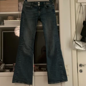 Blå bootcut jeans från Gina Tricot - Snygga blå bootcut jeans från Gina Tricot med dubbla knappar och dragkedja. Klassisk femficksdesign och lätt slitna detaljer för en trendig look. Perfekta för en avslappnad stil. Skriv privat om ni vill ha fler bilder💕