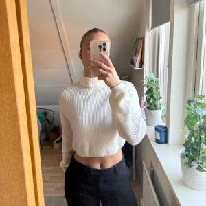 Vit ribbad croppad tröja - Säljer en stilren vit ribbad tröja med croppad passform. Tröjan har långa ärmar och en hög krage.🤍