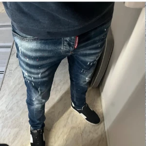Mörkblå jeans från Dsquared2 - Snygga mörkblå jeans från Dsquared2 med en cool 'ICON'-detalj på baksidan. De har en modern passform och slitna detaljer för en trendig look. 