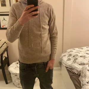 Beige cashmere hoodie - Helt oanvänd tröja, anledningen till att den säljs är för att den var för liten när den kom, nypris 1000kr. Storlek S, jag på bilden är 182cm så skulle rekommendera att vara ungefär 178-79