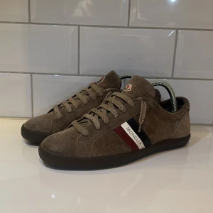 Bruna sneakers från Moncler - Snygga bruna sneakers från Moncler i mocka, riktigt bra skick som nya! Storlek 40 men passar 41-42