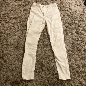 Vita byxor från H&M - Snygga vita byxor från H&M i storlek EUR 158. De har en klassisk design med fickor bak och en knappgylf framtill. 