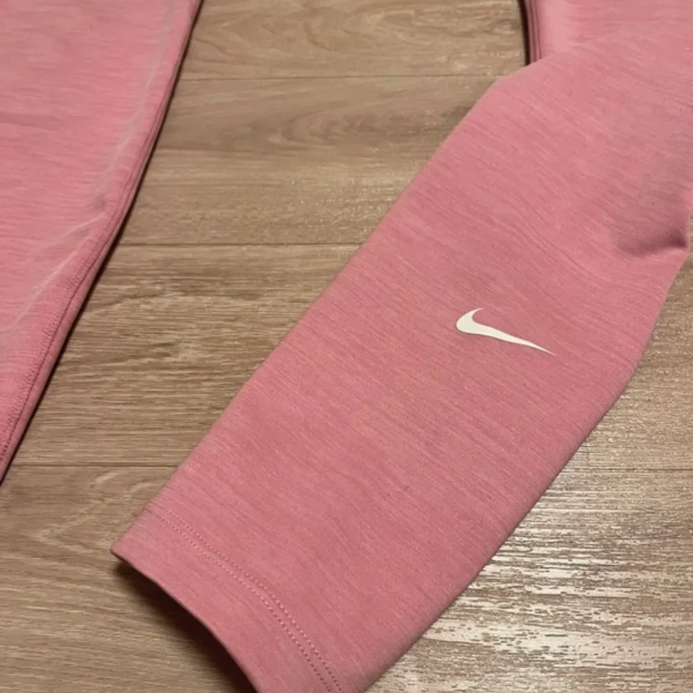 Säljer ett par rosa leggings från Nike med Dri-Fit teknologi. De är midwaiste och har en tight passform, perfekta för träning. Diskret Nike-logga på benet. Superbekväma och stilrena!. Farkut & Housut.