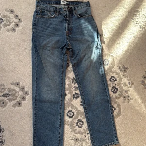 Blå jeans från 157 - Snygga blå jeans från 157 med klassisk femficksdesign och orange sömmar. De har en rak passform och är perfekta för en avslappnad stil. Midjan är w29 och längden är 32, vilket ger en bekväm passform.