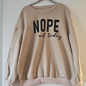 Beige sweatshirt från Shein - Säljer en beige sweatshirt från Shein med texten 'NOPE not today' tryckt på framsidan. Tröjan har långa ärmar och är tillverkad i 100% polyester. Perfekt för en avslappnad stil.