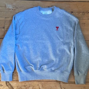 Grå sweatshirt från Ami Paris - ‼️ INTRESSEKOLL ‼️nypris är 3000kr kommer sälja den för 1000kr men pris går alltid att diskutera. Nyskick, har använt få gånger då storlek blev fel!  Kan även tänkta mig byta tröjan mot något med samma värde 