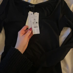 Svart långärmad topp från Gina Tricot - Säljer en stilren svart långärmad topp från Gina Tricot. Toppen har en rundad halsringning och är perfekt för en enkel och elegant look. Passar bra till både jeans och kjol. Perfekt för alla säsonger! HELT NY!!!!