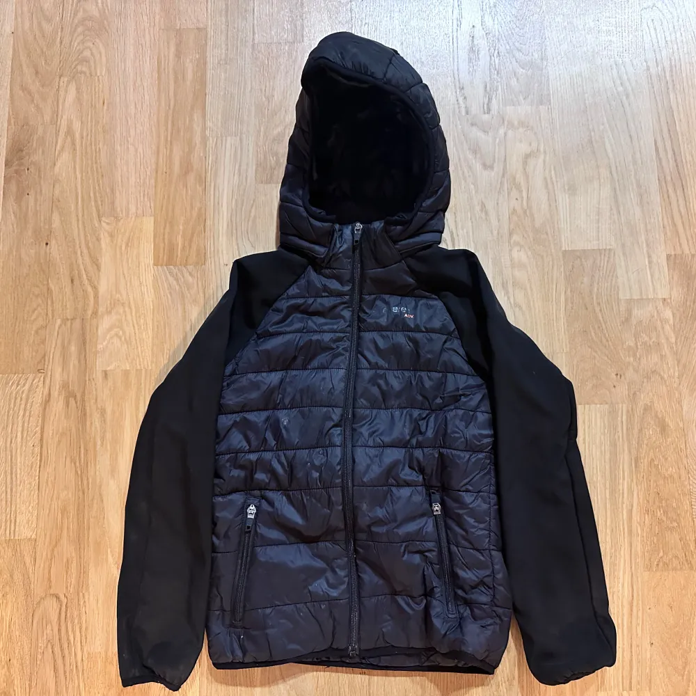 Säljer en svart pufferjacka från Nike med huva och dragkedja framtill. Jackan har långa ärmar och två praktiska fickor med dragkedja. Perfekt för kyligare dagar.. Takit.