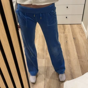 Blå mjukisbyxor från Juicy Couture - Snygga blå mjukisbyxor från Juicy Couture i storlek XS. Inte mycket använda och knappt slitna. Bra i längd för mig som är 169 cm