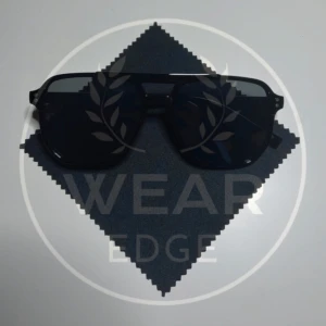 Svarta solglasögon från Wear Edge - Snygga svarta solglasögon med en modern design från Wear Edge. De har en klassisk aviatorform och mörka linser som ger ett stilrent intryck. Perfekta för att skydda ögonen mot solen med stil.