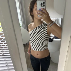 Randig oneshoulder topp - Randig oneshoulder topp i svart och vit. Aldrig använd 