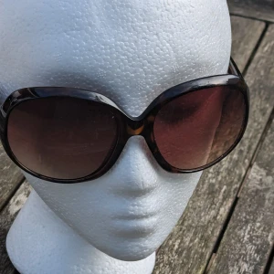 Solglasögon från H&M - Snygga solglasögon från H&M med en cool leopardmönstrad båge. De har stora, runda glas som ger en chic och retro look.I använt skick och har lite rispor, kontakta mig för flera bilder