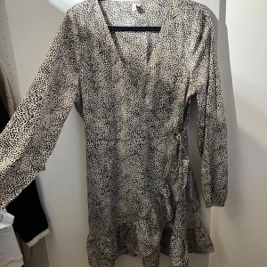 Klänning Nelly - En omlottklänning från Nelly i ett svart/vitt mönster. Str M  Aldrig använd men ingen lapp e kvar.  