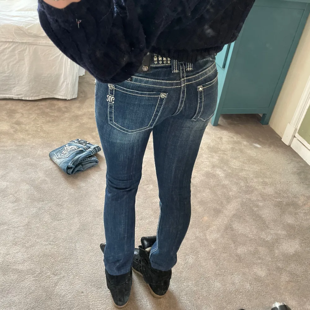 Så najs mörka miss me jeans, med nitar och andra detaljer längs linningen. Storlek: 26, midjemått: 82cm, innerbenslängd: 70cm, mått längst ner vid foten: 16 cm rakt över. Jeans & Byxor.