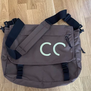 Axelremsväska - Går att justera längden på den. Man kan göra den större genom att dra i dragkedjan på sidan (se bild 2). Bokstäverna på framsidan håller på att försvinna annars inga defekter. Priset är diskuterbart :)