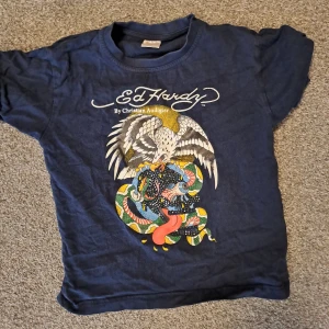 Ed hardy t-shirt - Väldig snygg ed hardy tröja i storlek xs. Den är fåtal använd men är köpt second hand och det finns paljetter som saknas.