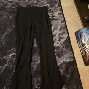 Svarta byxor - Säljer ett par svarta byxor i bra skick. De är högmidjade och har en bootcut-stil som ger en snygg siluett. Perfekta för både vardag och fest!