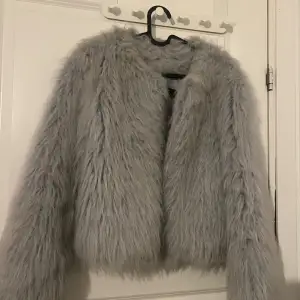 Säljer en supermjuk och fluffig grå pälsjacka från Zara Basic. Den är perfekt för att hålla sig varm och stilren under kyliga dagar. Jackan har långa ärmar och en snygg, enkel design som passar till alla outfits. Perfekt för höst och vinter!