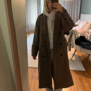 Brun kappa från object - Säljer denna beige bruna jackan från object i storlek 34. Använd ett fåtal gånger så i mycket fint skick. Perfekt kappa nu till hösten🍂🍁