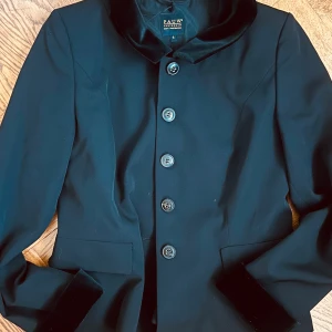 Svart kavaj från Ralph Lauren - Säljer en snygg  svart  kavaj Den har knappar framtill och en elegant krage. 