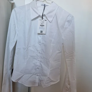 Figursydd skjorta strl XS/S - JÄTTEFIN figursydd skjorta från Bershka som sitter åt lite i midjan. Jag är normalt strl 36/38 elr S/M så jag köpte M men den passade mer som en XS/S och kunde därför inte ha den. Helt ny, endast testad :)