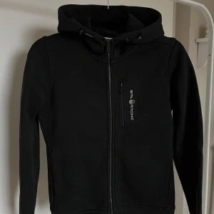 Svart zip-hoodie från Sail Racing - Snygg svart zip hoodie från Sail Racing i storlek S. Väldigt fint skick! Perfekt nu när det är kallare, då materialet är tjockt. Nypris ligger på 1500kr, och jag säljer den för 600kr. Bara att höra av er vid frågor eller funderingar!💞