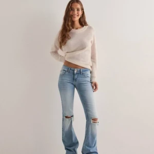 Ljusblå bootcut jeans - Snygga ljusblå bootcut jeans med slitna detaljer vid knäna. De har en låg midja och klassisk femficksdesign. Säljer då de inte kommer till användning. Passar mig som är 170 lång!🩷skriv om ni vill se egna bilder!