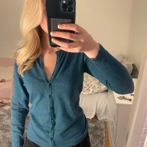 Blå kofta från Joy of Love - Säljer en stilren blå kofta från Joy of Love i storlek M. Koftan har långa ärmar och knappar framtill, perfekt för en avslappnad look. Passar bra till både jeans och kjol.