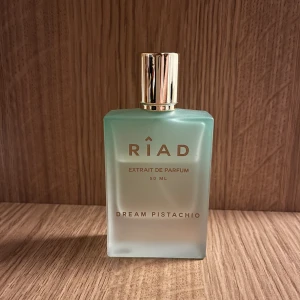 Dream Pistachio Extrait de Parfum från Riad -  Denna unika doftkomposition börjar med de delikata tonerna av vanilj, pistage och godis, och övergår gradvis till ett blomstrande hjärta av ros, ylang-ylang och sandelträ. Ordpris:1100 
