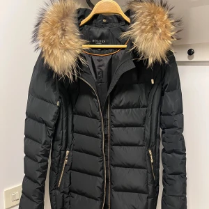 Hollies jacka i mycket bra skick!  - Jackan är i väldigt bra skick! Innehåller 80% dun & 20% fjäder. Jackan är egentligen storlek 42 men då Hollies jackor är väldigt små i storleken motsvarar den storlek 38. Kan funka för 40 med om man gillar att ha jackan tight. Nypris 5199kr. 
