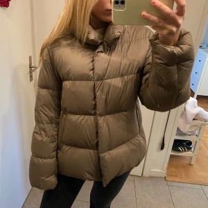 Beige pufferjacka - Säljer en snygg beige pufferjacka från uniqlo med långa ärmar och knappar. Perfekt till höst och vinter.Jackan är både varm och bekväm!