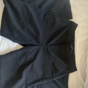 Svarta byxor från Gina Tricot - Snygga svarta byxor från Gina Tricot i storlek 34. Perfekta för en stilren look med en klassisk passform. Byxorna har en enkel design som gör dem lätta att matcha med olika toppar.