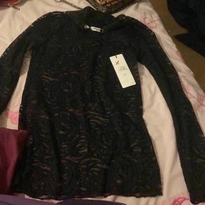 Svart spetsblus från Copenhagen Muse - Säljer en elegant svart spetsblus från Copenhagen Muse. Blusen har långa ärmar och ett vackert mönster som ger en sofistikerad look. Perfekt för att lyfta vilken outfit som helst. Ny med tagg!