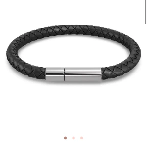 Svart flätat armband med metallspänne Edblad - Stilrent svart armband i flätat material med ett elegant metallspänne. Perfekt accessoar för en modern look. Kommer fråg Edblad, aldrig använt, nyskick, nypris 500kr storleken är small 18cm