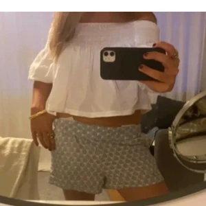 Vit offshoulder blus - Säljer en söt vit offshoulder blus med korta ärmar och smockdetaljer vid bysten. Perfekt för sommaren!. Passar bra till både shorts och jeans🩷